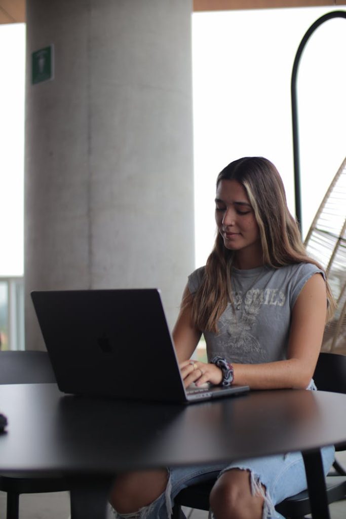 A woman sitting at a table with a laptop